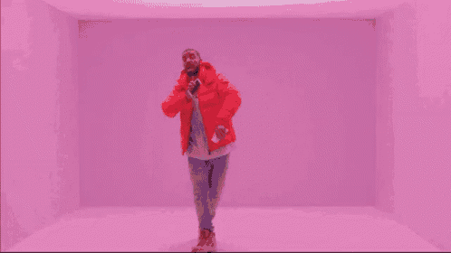 a man in a red jacket is dancing in a room .
