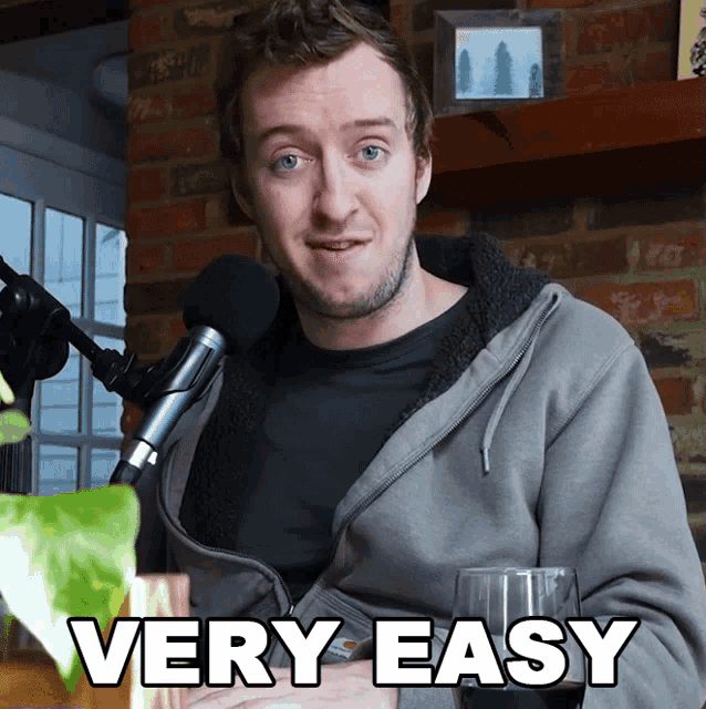 a man sitting in front of a microphone with the words " very easy " below him