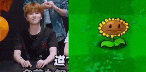 a man is sitting next to a cartoon sunflower with a smiling face .
