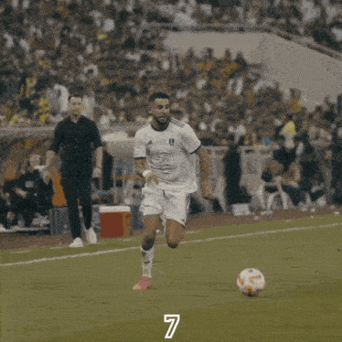 a soccer player with the number 7 on his jersey kicks the ball