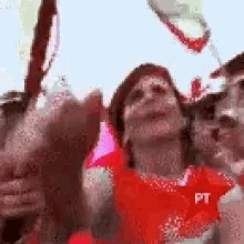 a group of people are toasting with bottles of wine and a pt logo in the corner .