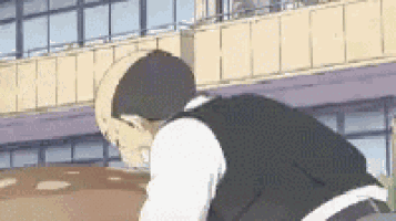 a man is kneeling down in front of a building with his head down .