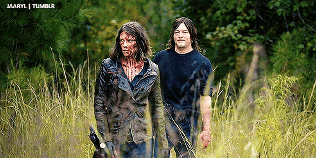 a man and a woman with blood on their faces are walking through tall grass