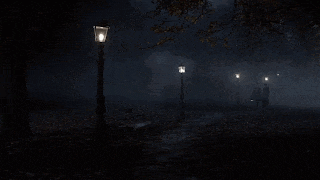 a couple walking in a park at night with lanterns