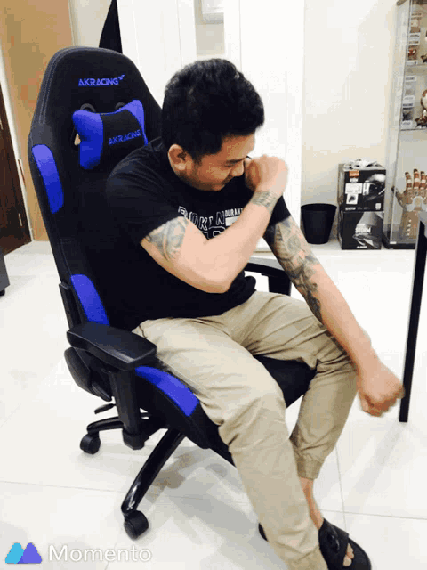 a man is sitting in an akracing chair with his arm outstretched