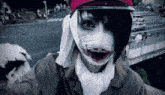 a close up of a person wearing a clown mask and a hat .