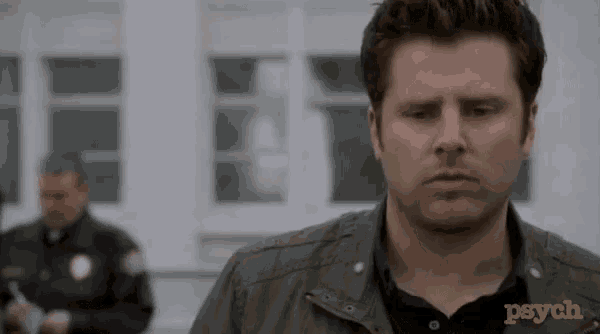 a man is standing in front of a police officer and the word psych is on his shirt