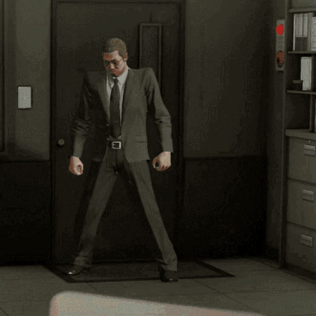 a man in a suit is standing in front of a door with a woman behind him