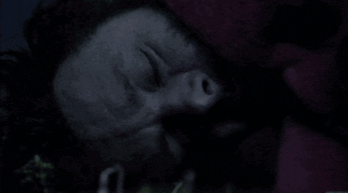 a close up of a person 's face in the dark with their eyes closed