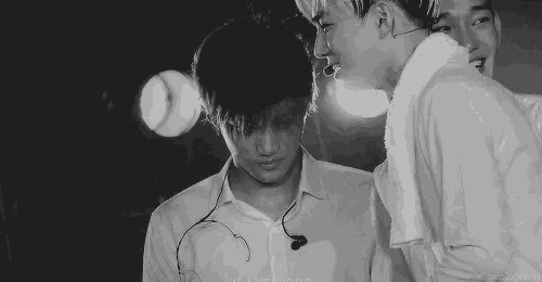 a black and white photo of two young men standing next to each other .