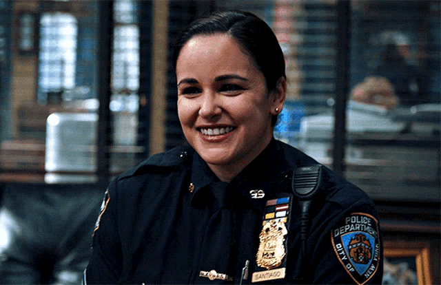 a woman in a police uniform is smiling and has a patch on her arm that says police department city of new york