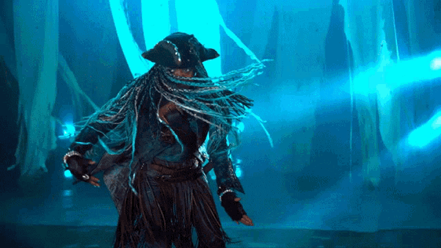 a woman in a pirate costume is dancing in a dark room