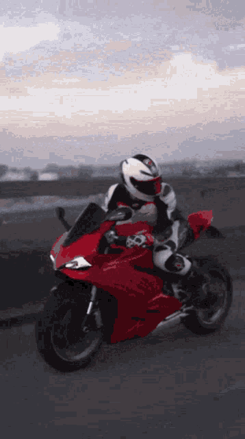 a person is riding a red ducati motorcycle on a bridge