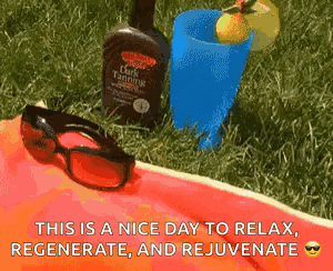 a bottle of dark tanning lotion sits next to a pair of sunglasses and a blue cup