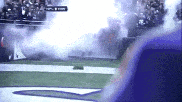 a football game is being played on cbs and smoke is coming out of the stands