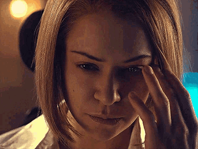 a close up of a woman touching her eye with her hand