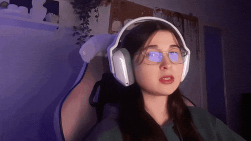 a woman wearing glasses and headphones is making a face