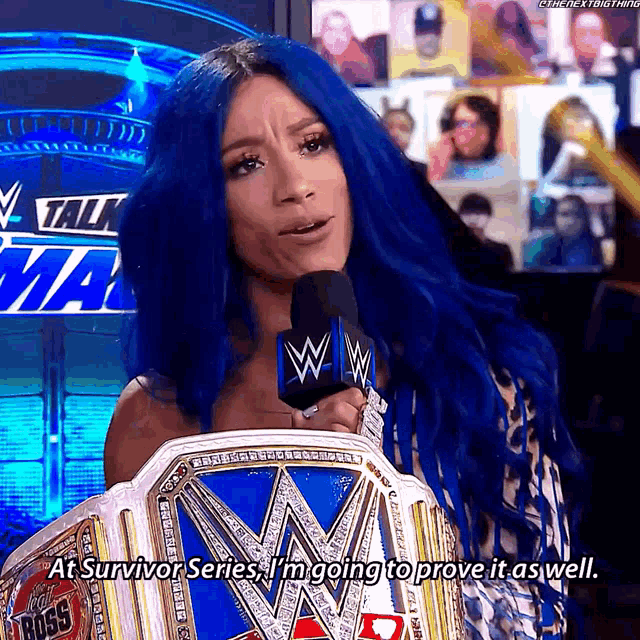 a woman with blue hair is holding a wrestling championship belt
