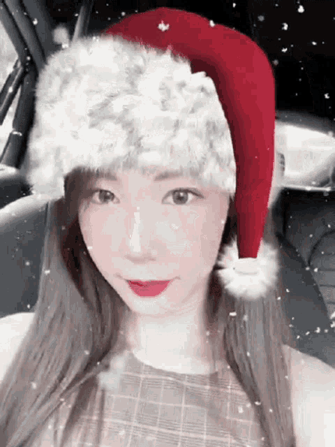 a woman wearing a santa hat is taking a selfie