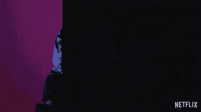 a woman is kneeling down in front of a purple and orange background with a netflix logo in the corner