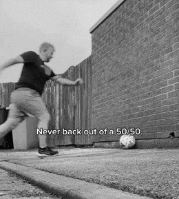 a black and white photo of a man kicking a soccer ball with the words never back out of a 50/50 below him