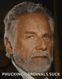 a man with a beard is wearing a suit and tie and is making a funny face .