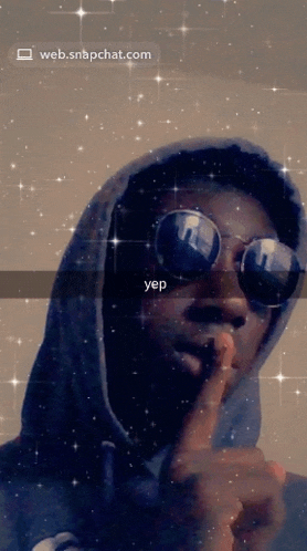 a man wearing sunglasses and a hoodie is making a shhh sign