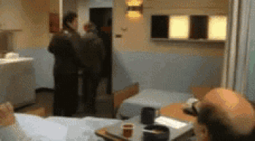 a blurry picture of a hospital room with a man sitting in bed