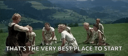 a group of people are sitting in a circle on top of a grassy hill .