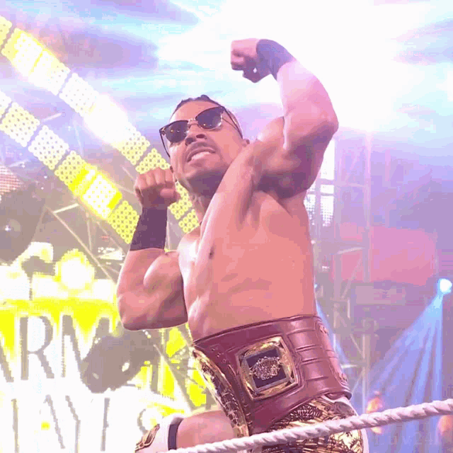 a shirtless wrestler wearing sunglasses and a belt stands in front of a sign that says rm lays