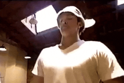 a man wearing a white hat and a white shirt is standing in a room with a skylight .