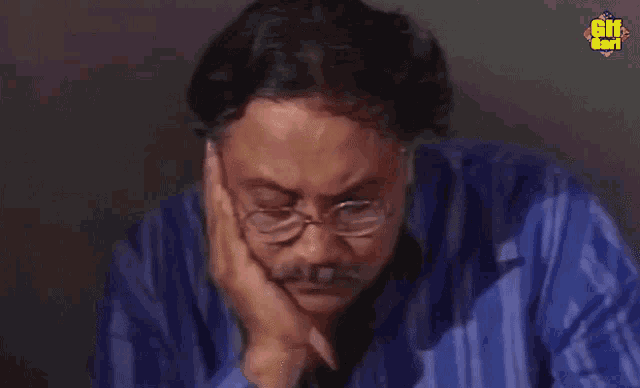 a man wearing glasses and a blue shirt has the word gif on the bottom left