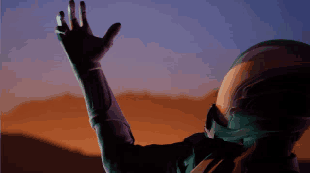 a person wearing a helmet reaches up towards the sky with their hand
