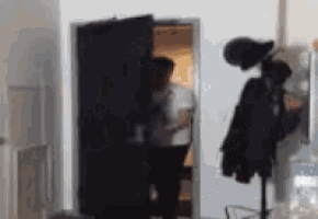 a blurry picture of two people standing in a doorway .