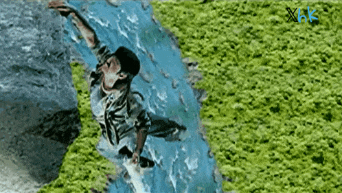 a man is falling into a river with xhk written on the bottom right