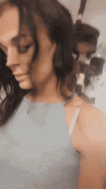a woman in a blue tank top is looking down at something