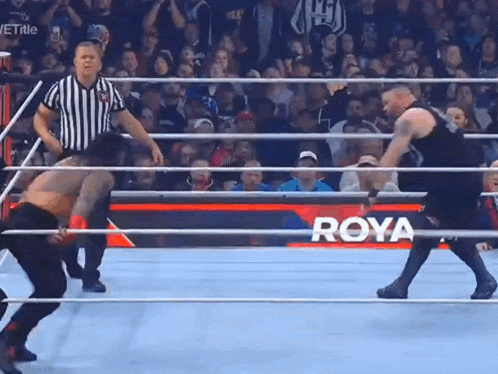 two men are wrestling in a ring with a sign that says roya