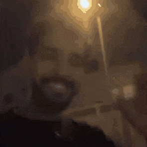 a man with a beard is smiling and holding a cell phone in his hand