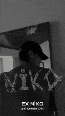 a person standing in front of a mirror with the word niko on their back