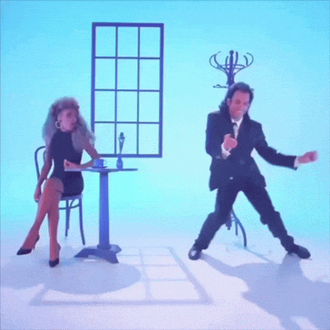 a man in a suit is kneeling down next to a woman in a black dress