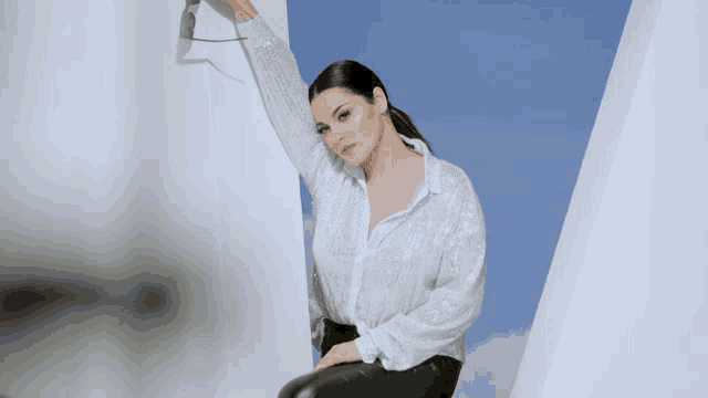 a woman in a sequined shirt and black pants