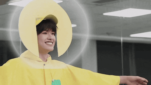 a man wearing a yellow hoodie and a yellow hat is smiling