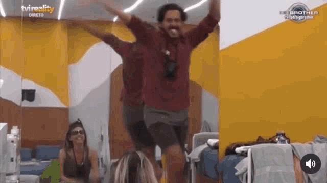 a man is jumping in the air with his arms outstretched in front of a tv reality logo .