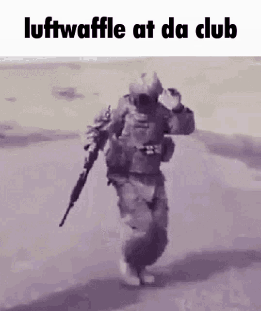 a soldier is holding a gun and walking down a road .