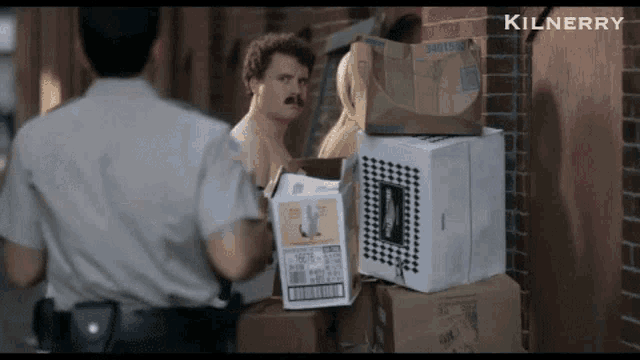 a man standing next to a pile of boxes with the word kilnerry on the bottom right