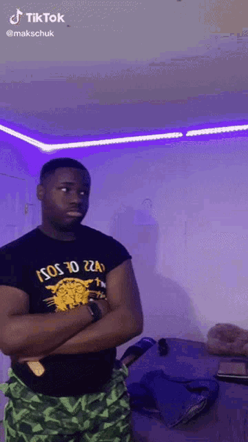 a man is standing in a room with his arms crossed wearing a black shirt that says ' isos to ' on it