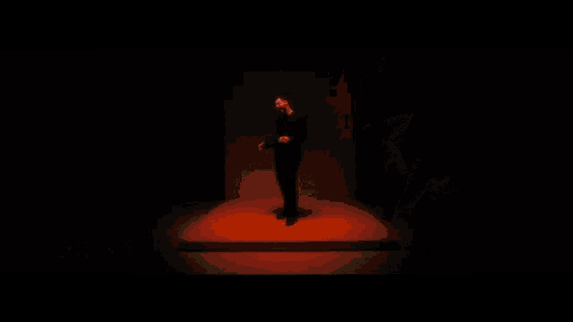 a man singing in front of a dark background with the name agoney m on the bottom right
