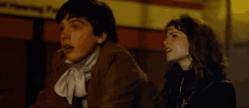 a man and a woman are sitting next to each other in a room .