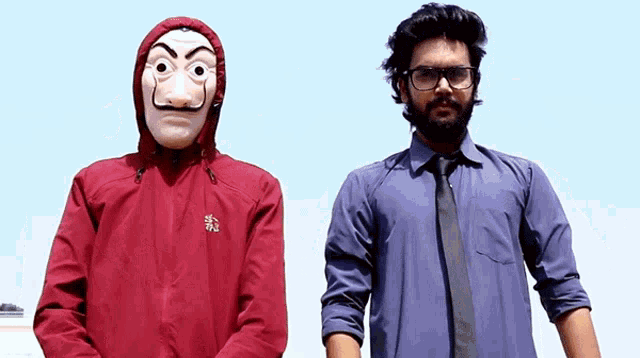 a man wearing a mask and a red jacket stands next to another man wearing glasses