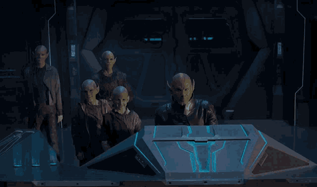 a group of aliens are standing around a blue box that says ' yt ' on it